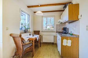 a small kitchen with a table and a sink at Ferienwohnungen Meerblick Herde in Göhren +102 photos