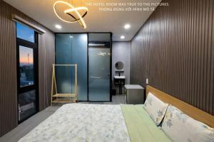 a bedroom with a bed and a glass door at Khách Sạn MINTNACIE in Phan Rang–Tháp Chàm