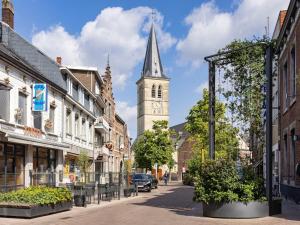 a city street with a church with a steeple at Charming ground-floor apartment in Bree in Bree