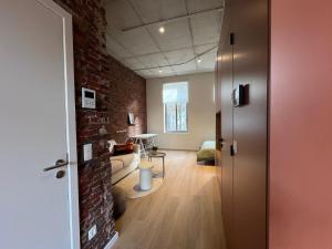 a living room with a brick wall and a door at Charming ground-floor apartment in Bree in Bree
