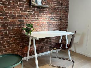 a white table with a plant on it next to a brick wall at Attractive apartment in Bree for 2 guests in Bree
