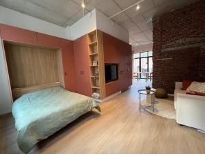 a bedroom with a bed and a couch in a room at Charming ground-floor apartment in Bree in Bree +11 photos