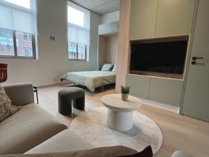 a living room with a couch and a tv at Attractive apartment in Bree for 2 guests in Bree
