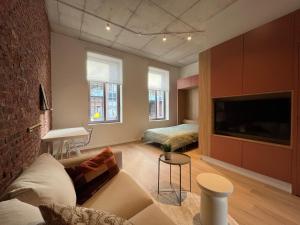 a living room with a couch and a tv at Charming ground-floor apartment in Bree in Bree