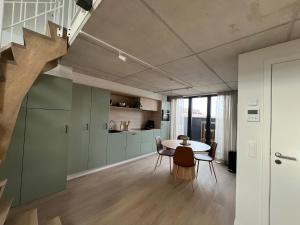 a kitchen and dining room with a table and a staircase at Inviting apartment in Bree with terrace in Bree +11 photos