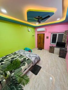 a bedroom with green and pink walls and a bed at Aras Homestay New Hampi in Hampi