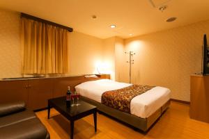 um quarto de hotel com uma cama e um sofá em Hotel Moana Otsuka (Adult Only) em Tóquio