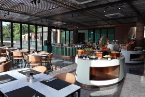 a restaurant with white tables and chairs and windows at Wyndham Garden Phuket Kamala in Kamala Beach +86 photos