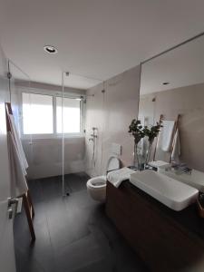 a bathroom with a sink and a toilet and a shower at Deluxe 2 Terraces River&Marina View Flat in Ferragudo +41 photos