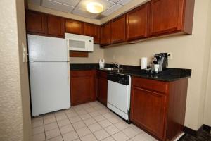 a kitchen with wooden cabinets and a white refrigerator at Quality Inn & Suites Downtown Mansfield in Mansfield