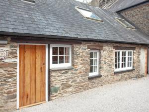 a stone building with a wooden door and two windows at Tuckenhay, 3 Salle Cottage- Fcs in Ashsprington +38 photos