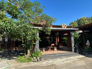 a house with a tree in front of it at Homestay Joglo Kembar in Gading