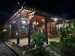 a house with a courtyard at night at Homestay Joglo Kembar in Gading