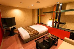 Hotel Moana Otsuka (Adult Only) في طوكيو: غرفة فندقية بسرير وتلفزيون بشاشة مسطحة