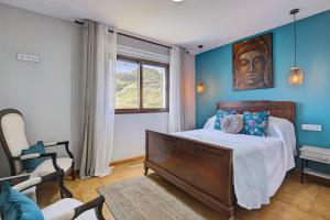 a bedroom with a bed with blue walls at VV La Karajita in Mazo