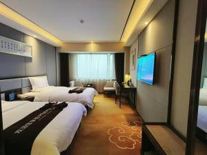 a hotel room with three beds and a television at Yihe Hotel Luoyang in Luoyang