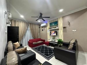 a living room with a couch and a ceiling fan at Reisya Homestay in Kepala Batas