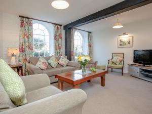 a living room with a couch and a tv at Tuckenhay, Milbourn Cottage - Fcu in Ashsprington +42 photos