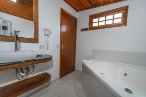 Un baño con bañera, lavabo y teléfono. en Hotel Ascona, en Campos do Jordão 55 fotos más