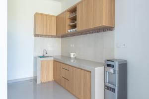 a kitchen with wooden cabinets and a sink at Nang Aji House in Ungasan