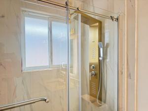 a shower with a glass door in a bathroom at Spacious 2 BR Suite with Parking, Backyard & Desk in Toronto