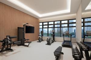 a gym with several treadmills and a flat screen tv at NOVOTEL Zhoushan Luting in Zhoushan