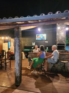 a group of people sitting in a bar at Sitio em Capim Branco in Capim Branco