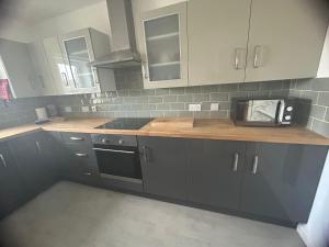 a kitchen with gray cabinets and a counter top at Acorn Apartment in Dufftown