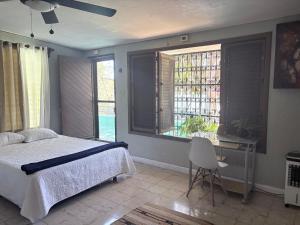 a bedroom with a bed and a desk and windows at Casa Buenavista in Mérida +30 photos