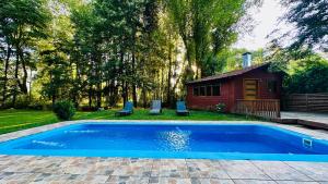 a swimming pool in a yard with a house at Cabaña Roca Volcán in Melipeuco