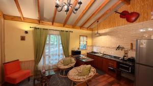 a kitchen with a counter and chairs and a refrigerator at Cabaña Roca Volcán in Melipeuco