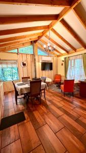 a living room with a table and chairs and a tv at Cabaña Roca Volcán in Melipeuco
