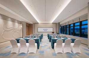 a conference room with blue tables and white chairs at NOVOTEL Zhoushan Luting in Zhoushan