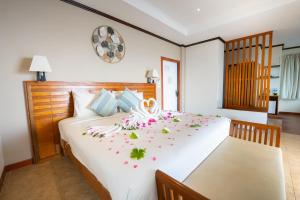 a bedroom with a large white bed with flowers on it at Pinnacle Koh Tao Resort in Ko Tao