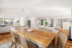 a kitchen and living room with a wooden table and chairs at Ivory Sands, Sorrento in Sorrento