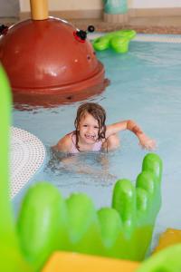 a little girl swimming in a swimming pool at Smileys Kinderhotel in Trebesing