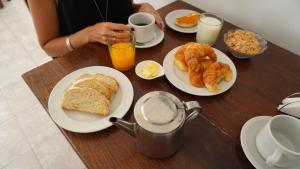a table topped with plates of breakfast foods and orange juice at HOTEL APOLO NEUQUEN in Neuquén