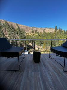 two chairs on a deck with a view of a mountain at Xaxa Lodge in Tarma