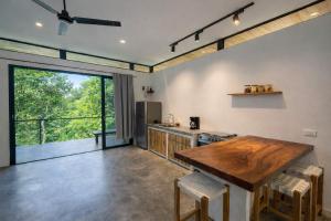 a kitchen with a wooden table and a large window at Calma Ometepe in Santa Cruz