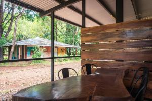 a wooden table in a room with a view of a house at Banyan Tree Holiday Park in Rum Jungle Station