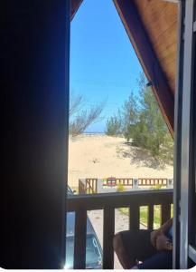 a room with a view of a beach from a window at Chalé Ahmar! in Jaguaruna