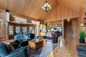 a living room with leather couches and a table at Fiddler Lake Resort - Deer 61 in Mille-Isles