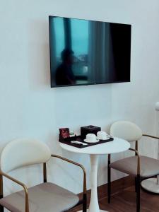 a table with two chairs and a tv on a wall at Sky Hotel in Ninh Binh