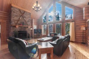 a living room with leather furniture and a fireplace at Fiddler Lake Resort - Deer 61 in Mille-Isles