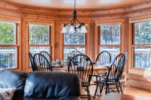 a dining room with a table and chairs and windows at Fiddler Lake Resort - Deer 61 in Mille-Isles