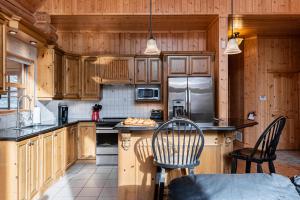 a kitchen with wooden cabinets and a counter with chairs at Fiddler Lake Resort - Deer 61 in Mille-Isles