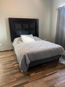 a bedroom with a bed and a wooden floor at Casa Serena in Hermosillo +49 photos