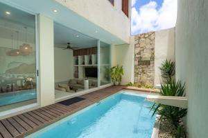 a swimming pool in a house with a patio at SandWave Villa by Betterplace in Ungasan +33 photos