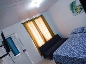 a small bedroom with a bed and a curtain at Sweetroom Miss Gloria in Estación El Salto