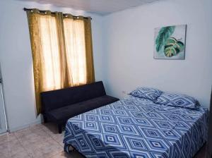 a bedroom with a bed and a chair and a window at Sweetroom Miss Gloria in Estación El Salto